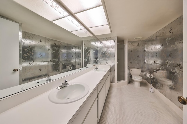 bathroom featuring tile patterned floors, vanity, toilet, and a shower with door