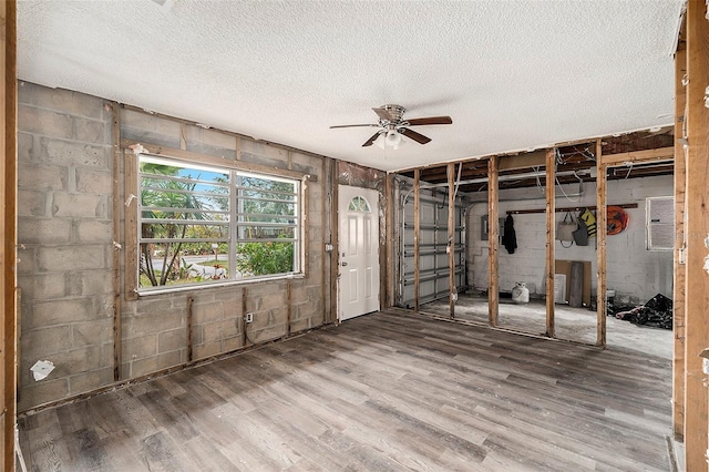 basement featuring ceiling fan, a textured ceiling, and hardwood / wood-style flooring