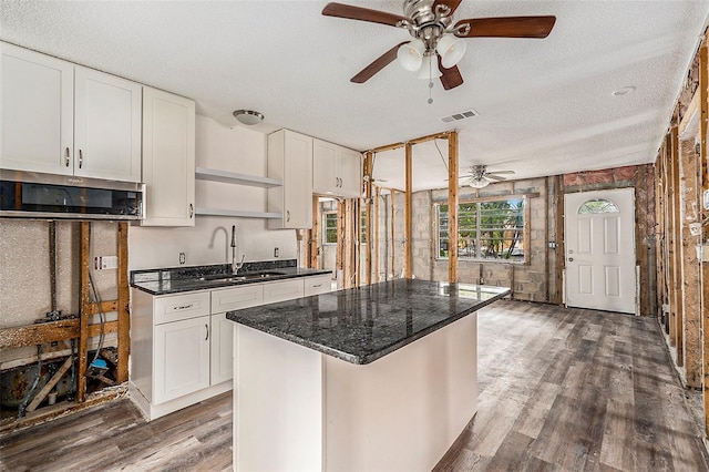 kitchen featuring ceiling fan, sink, dark wood-type flooring, a textured ceiling, and white cabinets