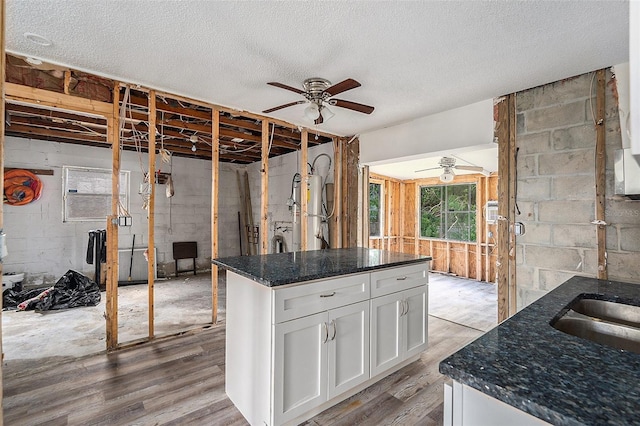 kitchen with a center island, light hardwood / wood-style flooring, white cabinets, and a textured ceiling