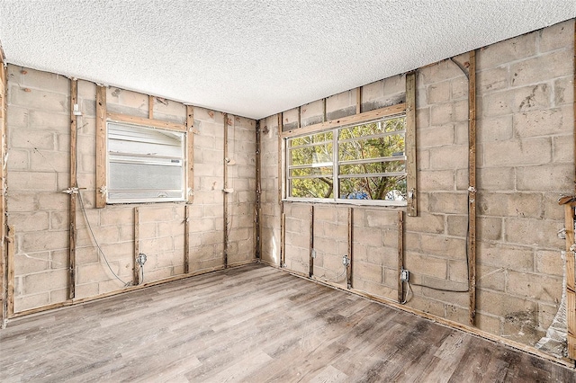 unfurnished room with a textured ceiling and hardwood / wood-style flooring