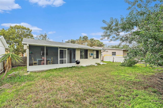 back of property with a yard and a sunroom