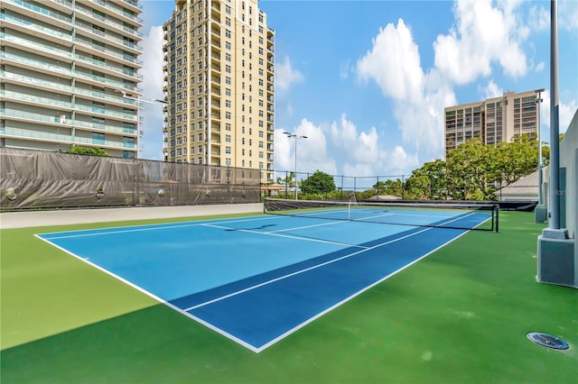 view of tennis court featuring basketball hoop