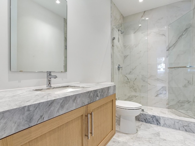 bathroom featuring tiled shower, vanity, and toilet