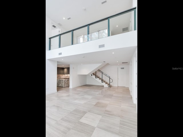 living room featuring light tile patterned floors and a towering ceiling