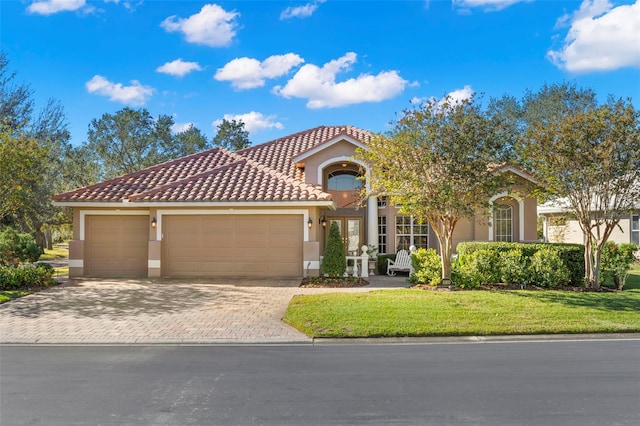 mediterranean / spanish home with a front yard, french doors, and a garage