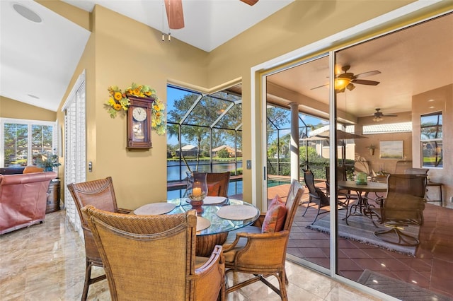 dining area with plenty of natural light, ceiling fan, and a water view