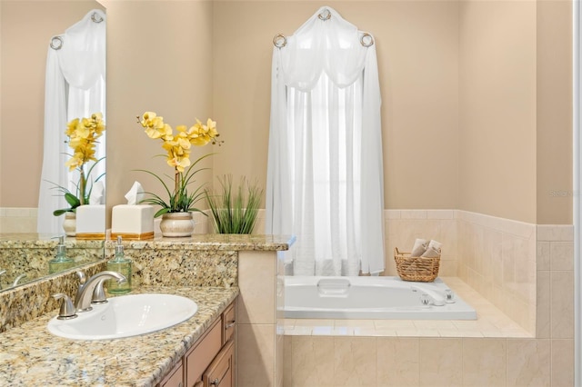 bathroom with vanity and tiled bath