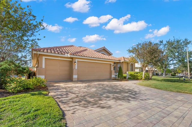 mediterranean / spanish home with a garage and a front lawn