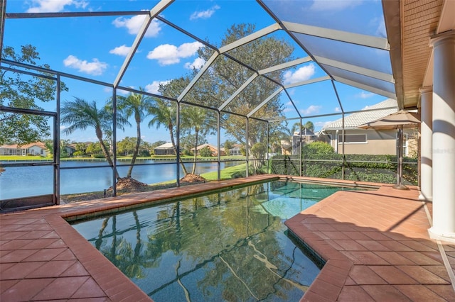 view of swimming pool with a patio area, a water view, and glass enclosure