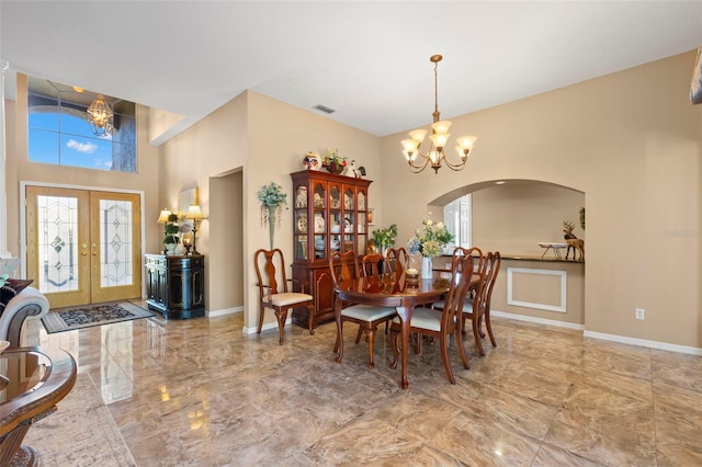 dining area with french doors and a chandelier