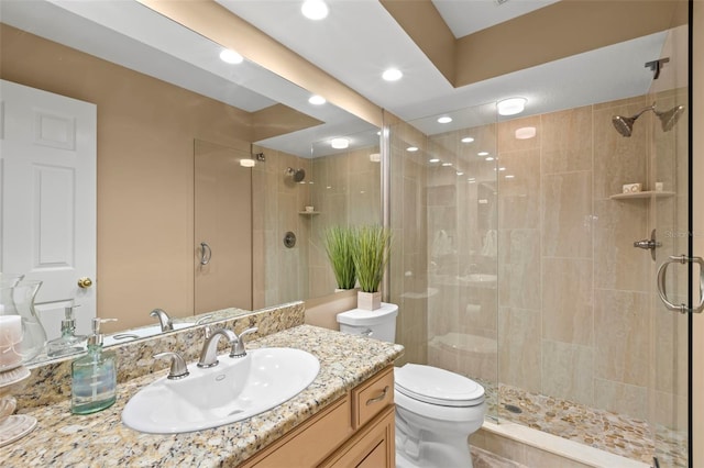 bathroom with toilet, vanity, and walk in shower