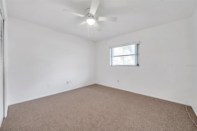 carpeted spare room featuring ceiling fan