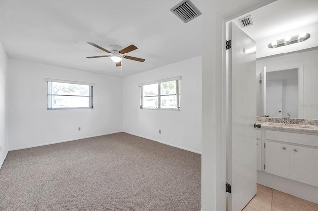 carpeted spare room with sink and ceiling fan