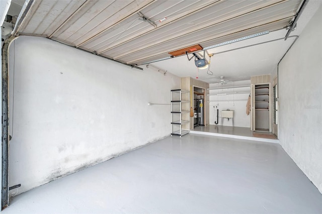 garage featuring a garage door opener, electric water heater, and sink