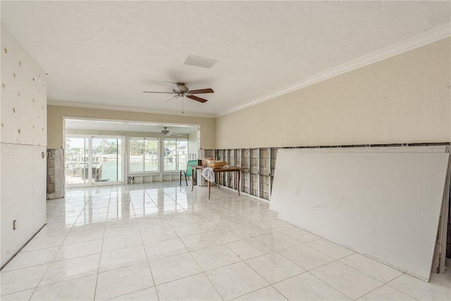 tiled spare room featuring ceiling fan and ornamental molding