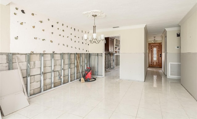 spare room with a notable chandelier, light tile patterned flooring, and ornamental molding