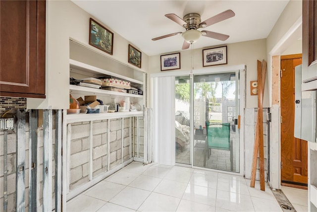 doorway featuring ceiling fan and light tile patterned flooring