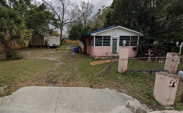 bungalow-style house with a storage unit