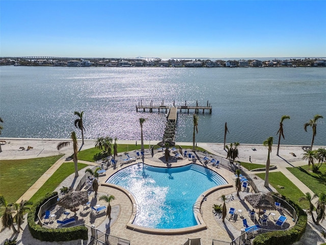 view of swimming pool featuring a water view and a dock