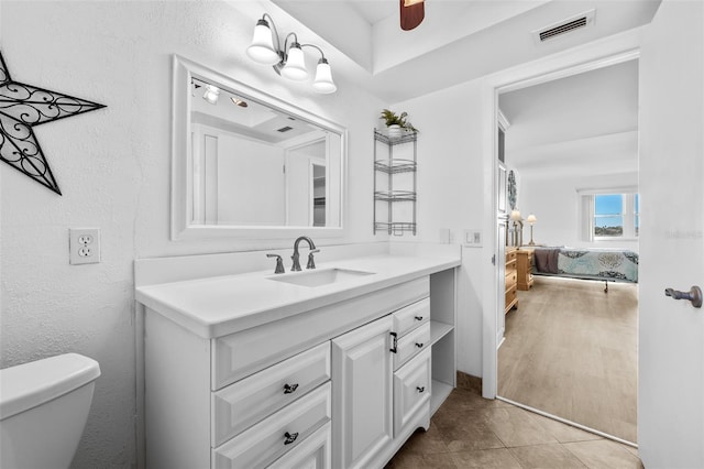 bathroom featuring ceiling fan, vanity, wood-type flooring, and toilet