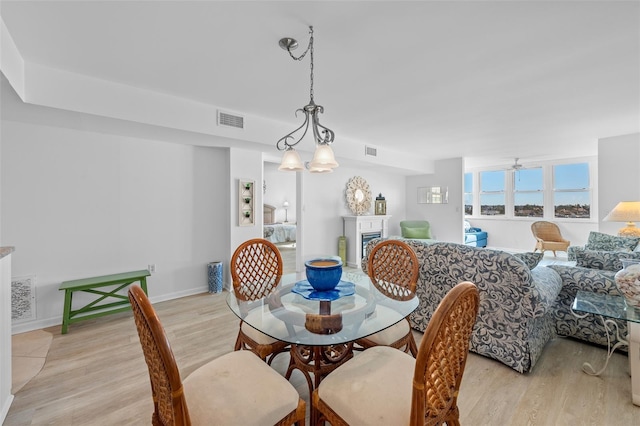 dining room with an inviting chandelier and light hardwood / wood-style flooring