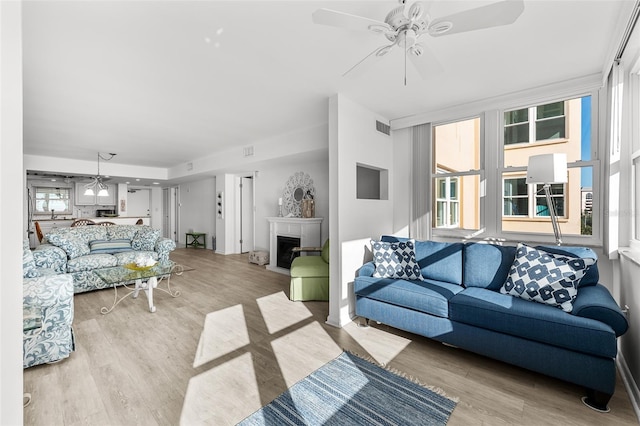 living room featuring a wealth of natural light, ceiling fan, and light wood-type flooring