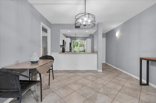 dining space with a chandelier and light tile patterned flooring