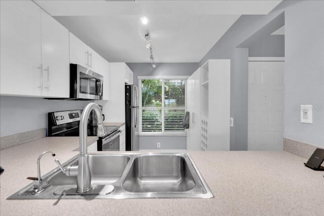 kitchen with sink, white cabinetry, stainless steel appliances, and track lighting