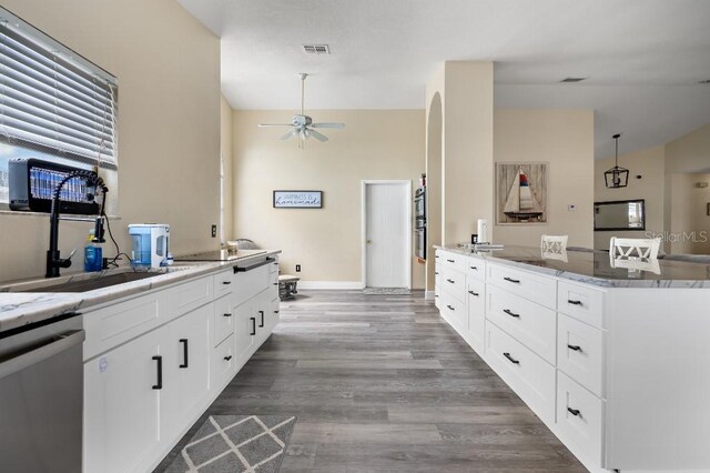 kitchen featuring white cabinets, light wood-type flooring, stainless steel dishwasher, and ceiling fan