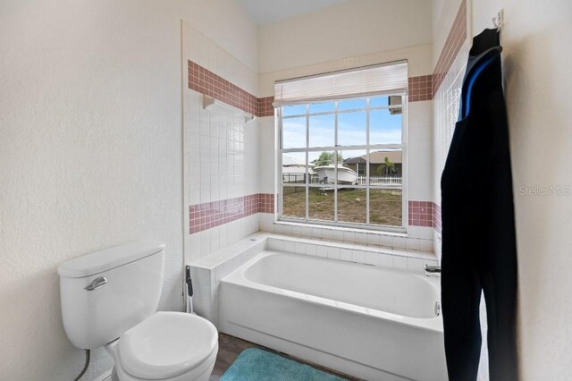 bathroom featuring a bath and toilet