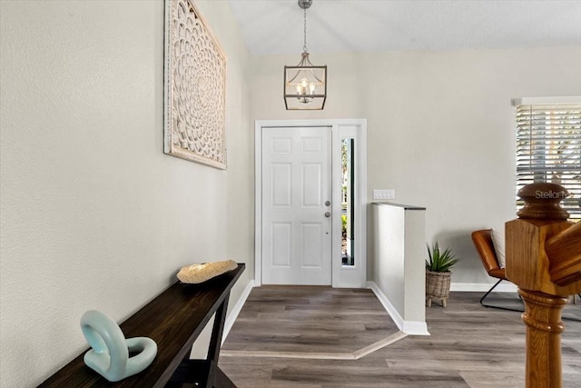 entryway with hardwood / wood-style floors and an inviting chandelier