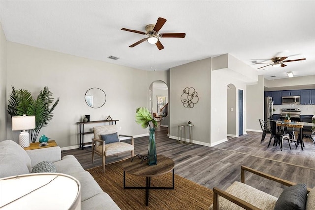 living room with ceiling fan and dark hardwood / wood-style flooring