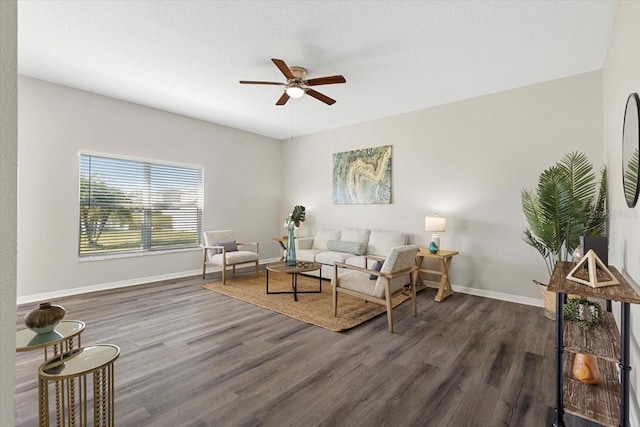 living room with ceiling fan and dark wood-type flooring