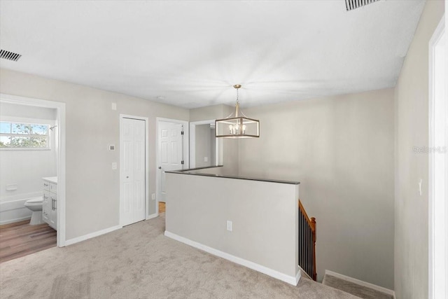 unfurnished dining area with light carpet and a chandelier