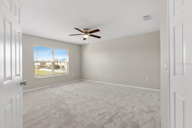 carpeted spare room featuring a textured ceiling and ceiling fan