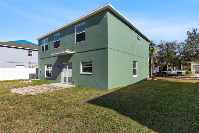 rear view of house with a lawn and cooling unit