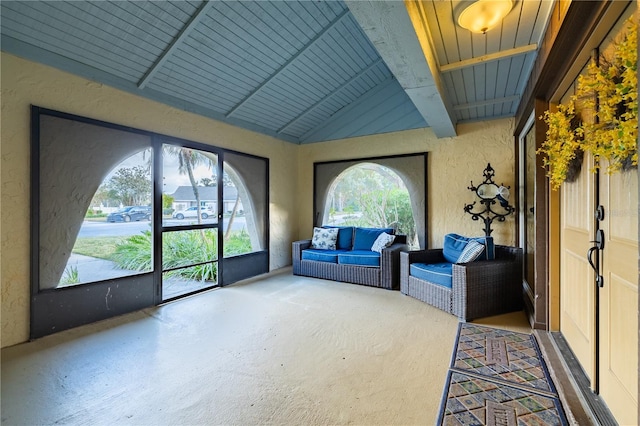 unfurnished sunroom featuring beam ceiling, wooden ceiling, and a healthy amount of sunlight