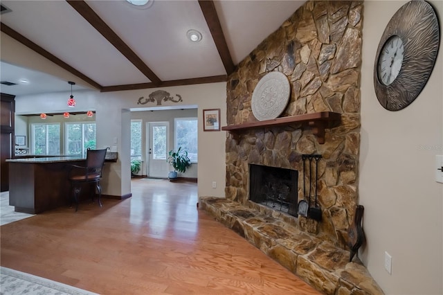 living room with a fireplace, beamed ceiling, and hardwood / wood-style flooring