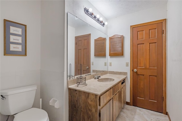 bathroom with vanity, a textured ceiling, and toilet