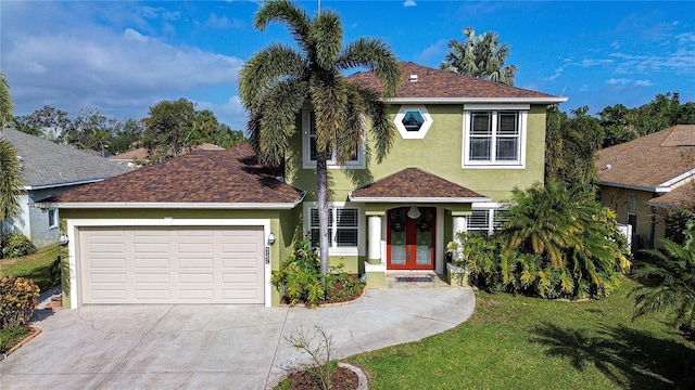 view of front of home with french doors, a garage, and a front lawn