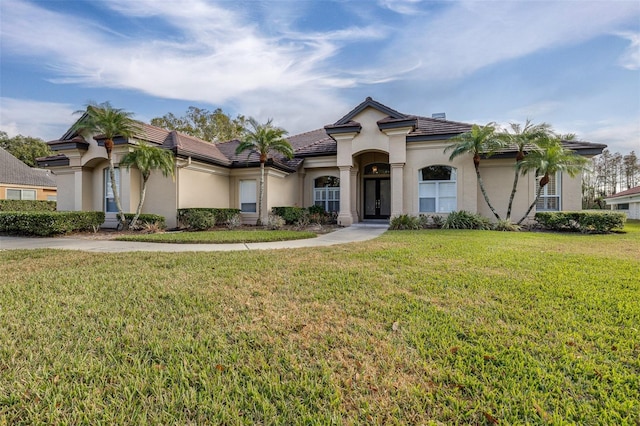 mediterranean / spanish house featuring a front yard