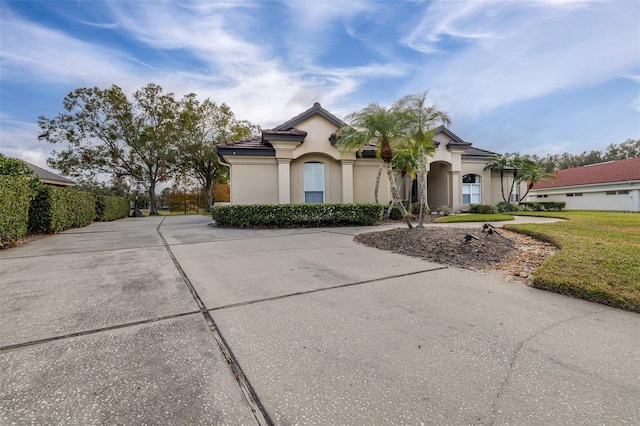 mediterranean / spanish home with a front lawn