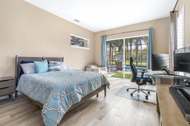 bedroom with light wood-type flooring and access to outside