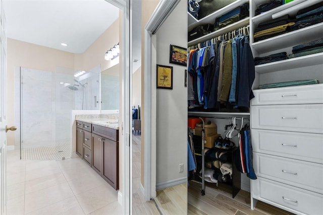 bathroom with a tile shower, vanity, and hardwood / wood-style floors