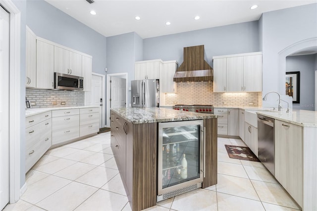 kitchen featuring backsplash, stainless steel appliances, beverage cooler, and wall chimney exhaust hood