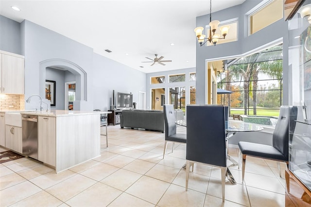 dining room featuring sink, light tile patterned flooring, and ceiling fan with notable chandelier