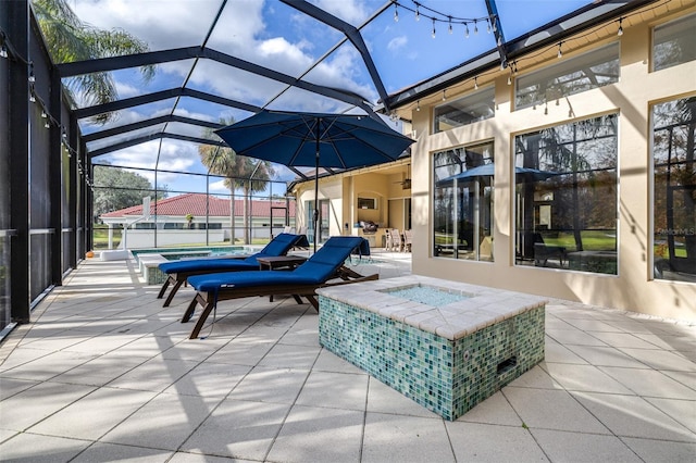 view of patio / terrace featuring glass enclosure and an outdoor fire pit