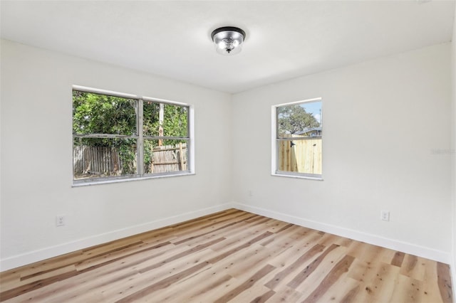 unfurnished room with light wood-type flooring and a healthy amount of sunlight