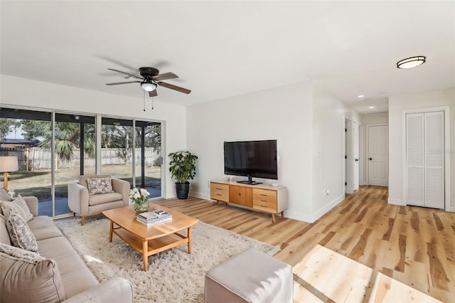 living room with ceiling fan and light hardwood / wood-style flooring